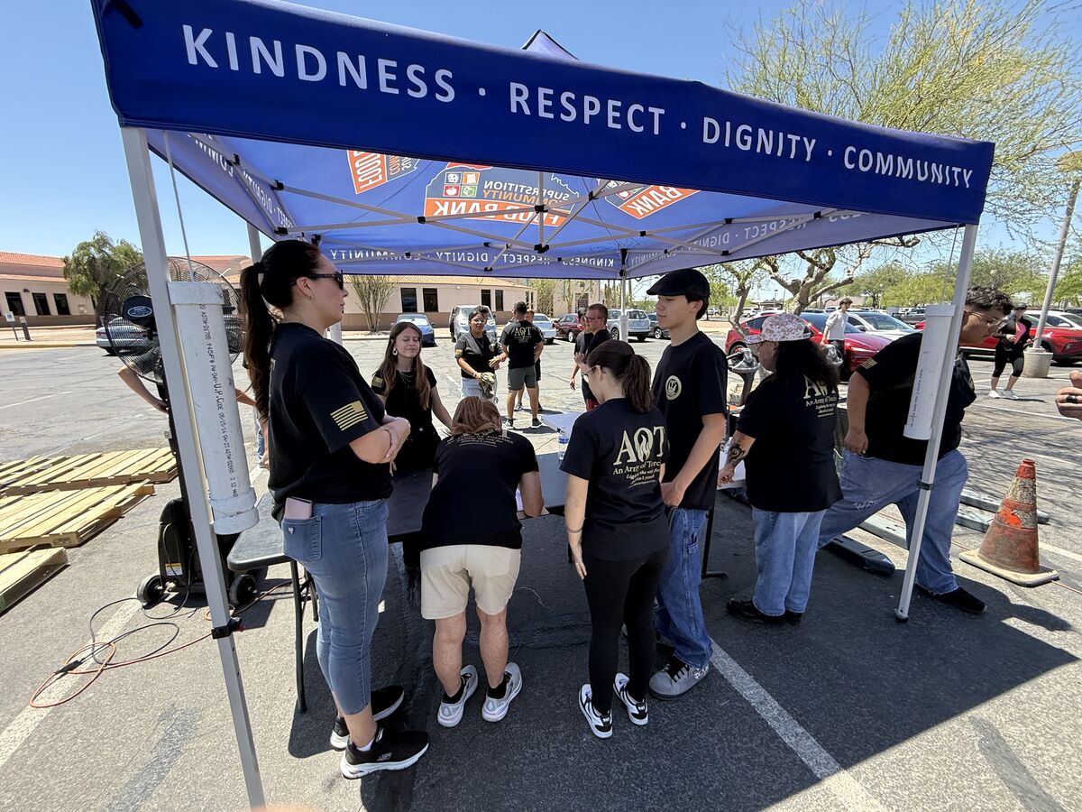 AOT volunteers gathered under the Kindness Respect Dignity Community tent at the food bank