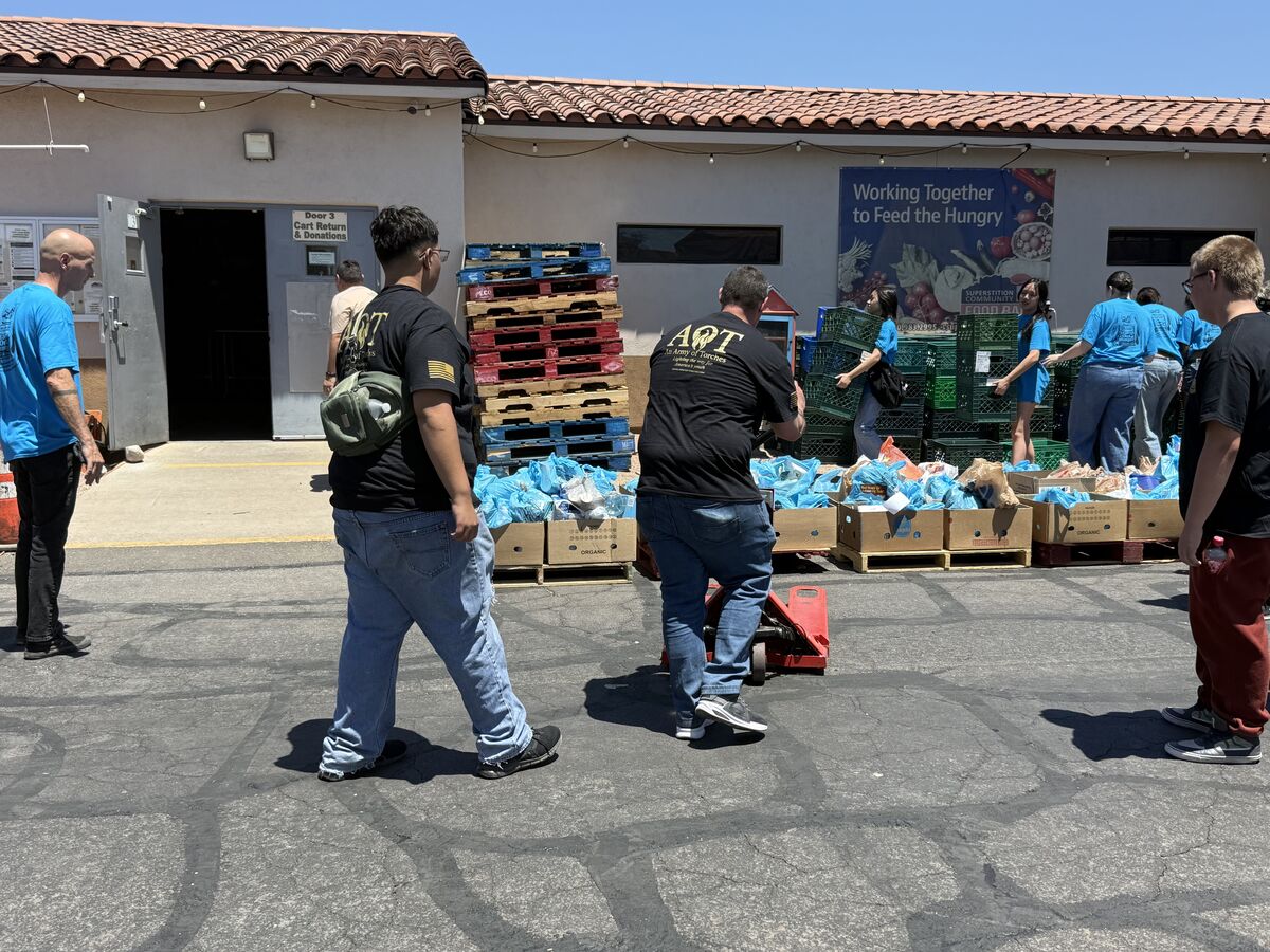 AOT volunteers walking toward the Working Together to Feed the Hungry banner at the food bank